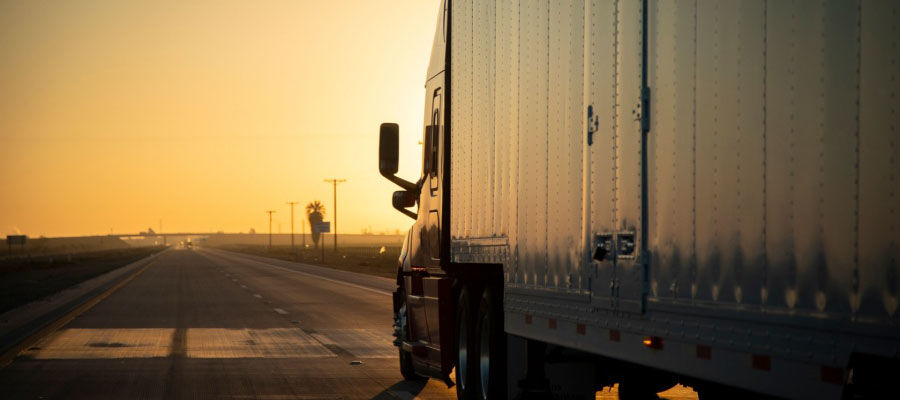 semi truck heading into the sunset